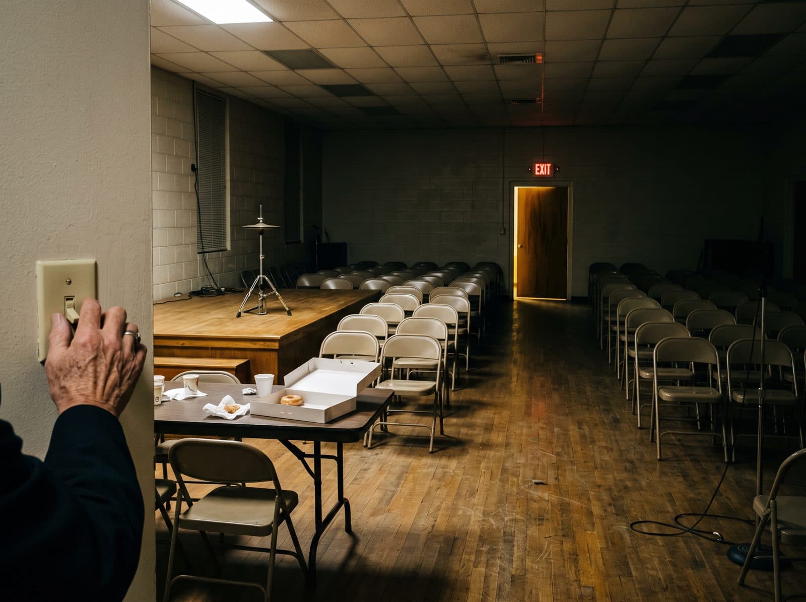 An empty fellowship hall with the lights going off